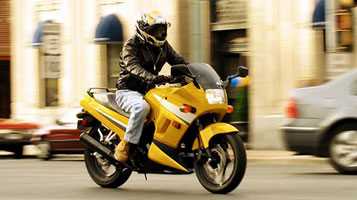 photo: man riding a yellow motorcycle on an urban road