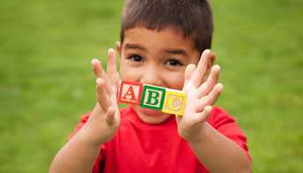 Boy holding A, B, and C wooden blocks
