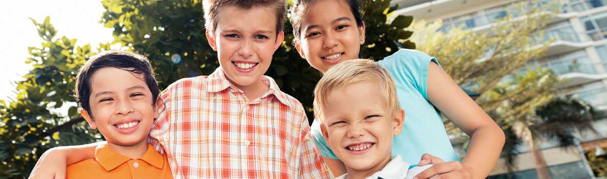 A group of four children smiling 