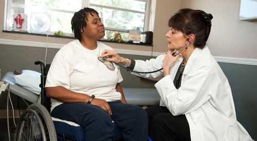 A woman in a wheelchair visiting her doctor 