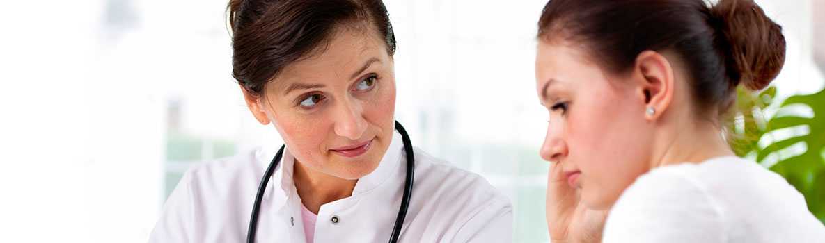 Female doctor and female patient looking over clipboard