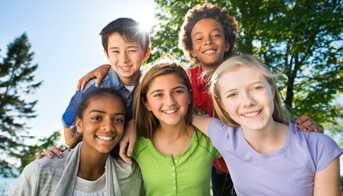 Group of kids huddling for a picture in a park