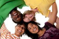 Four kids laying with their heads together