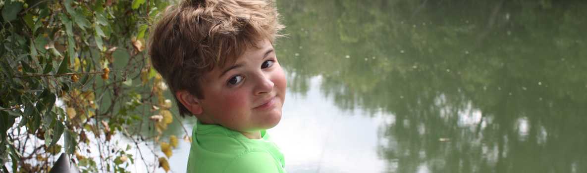 Boy beside riverbank