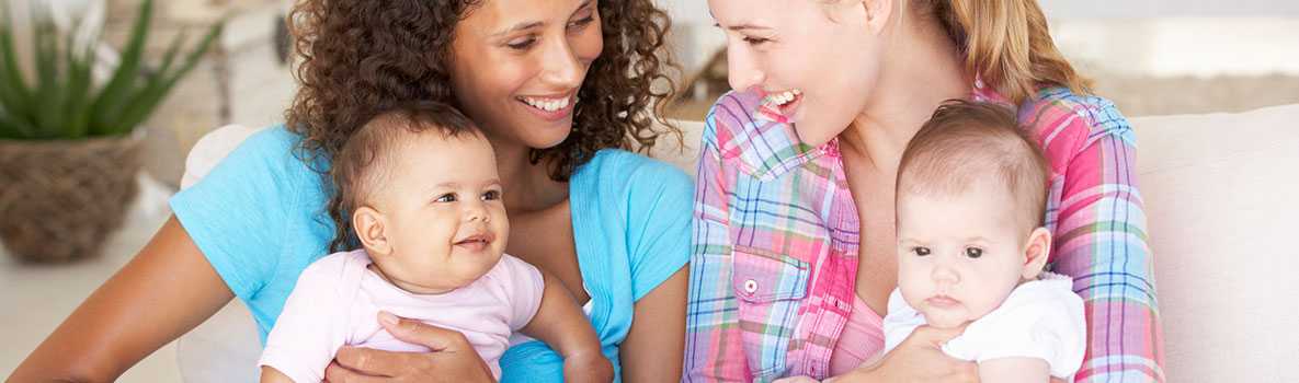 Two young mothers holding their babies 