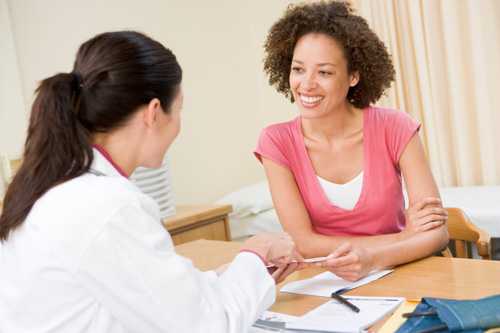 Doctor sitting at her desk with a patient