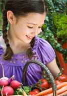 Young girl holding basket of vegetables