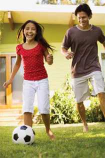 Two teens playing soccer.