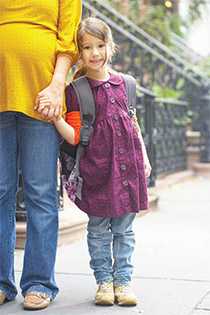 Young girl holding hands with her mother