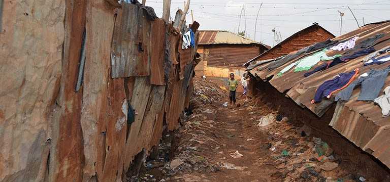 boy in littered shanty town