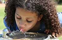 Girl drinking out of water fountain