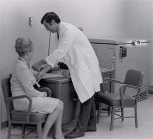 A black and white image an exam being performed in the Arctic Investigations Program's previous building.