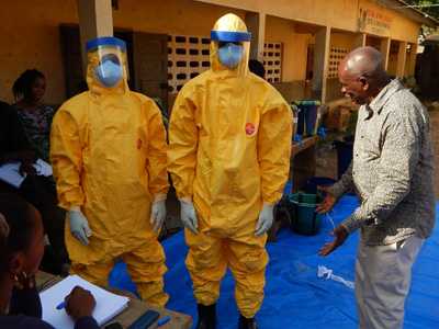 Training is provided for Red Cross volunteers during the Ebola response. Here, Guinean Professor Lamine Koivogui, is doing hands-on training with two individuals in yellow protective gear.