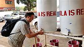 Photo: Brian Harcourt washing his hands during January 2015 in chlorinated water outside in Liberia―where the water tanks remind you that 'EBOLA IS REAL.'