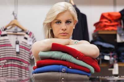 Woman standing with arms crossed on pile of clothing