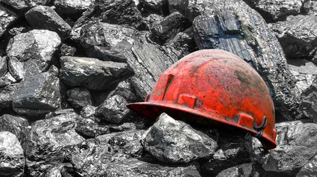 A miner's helmut on a mound of coal