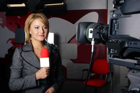 News correspondant reporting news in front of a television camera.