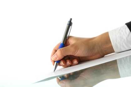 Man writing a memo to staff on a sheet of paper.