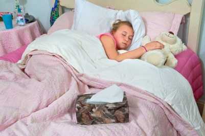 Young girl at home sick in bed.