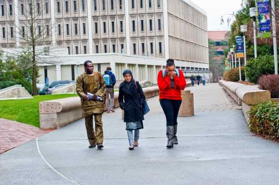 3 college students walking on campus.