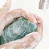 Close-up of a pair of human hands washing with soap