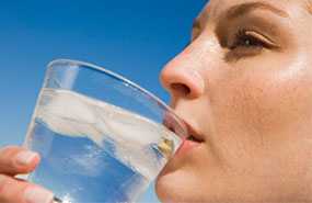 	A woman drinking a glass of water