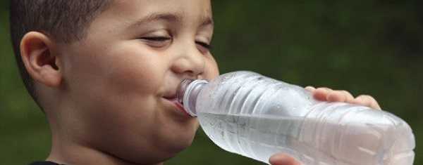 Young boy drinking a bottle of water