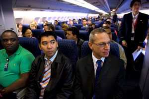 Passengers and flight attendant on an airplane.