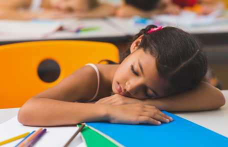 Una niña durmiendo en la clase