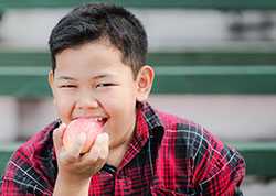 Niño comiendo fruta. 