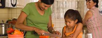 Madre, hija y nieto en la cocina en la preparación de alimentos.