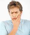 Boy holding jaw in pain.