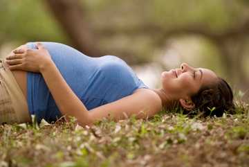 Pregnant woman lying on grass