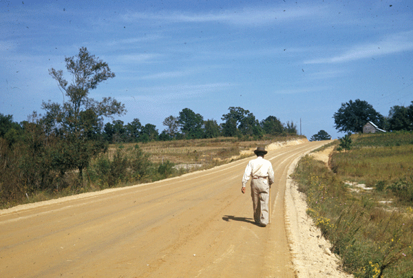 man walking down a dirt road