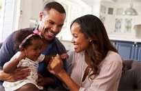 Father and mother playing with infant.