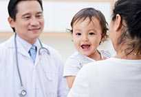 Baby smiling with doctor and mother