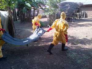 	Workers wearing protective clothing carrying a body bag