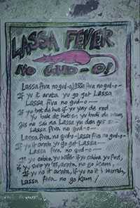 panneau portant l’inscription Lassa Fever no gud-o! Lassa fiva no gud-0, lassa fiva no gud-o if yu it arata yu go get lassa lassa fiva no gud-o if yu trot de hut if yu yay de red yu bak de hut en yu don get so lassa fiva no gud o lassa fiva no gud o