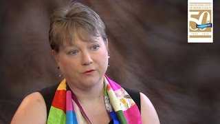 Woman being interviewed with colorful scarf around her neck