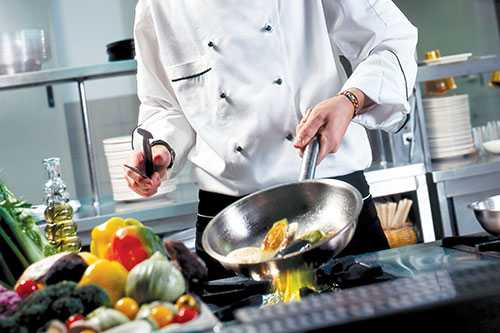 A chef cooking with a wok in the kitchen