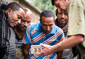 The trainees watch a slow-motion video of their technique on a cell phone.